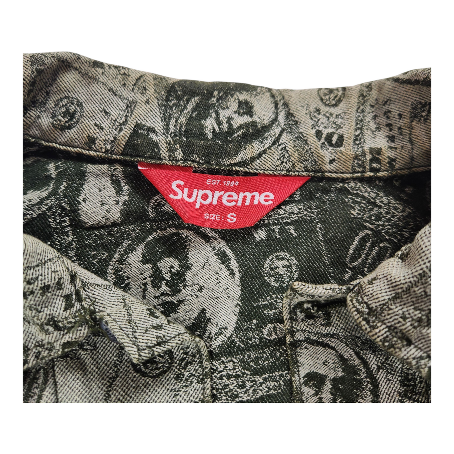 Close-up of a patterned fabric with a Supreme label on a white background