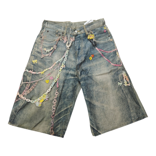 Denim shorts with decorative chains and flowers on a white background